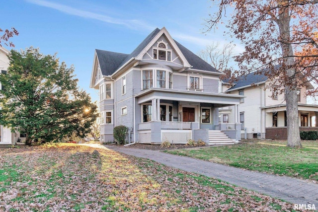 victorian home with a front yard and covered porch