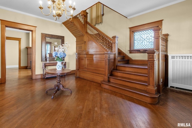 staircase featuring ornamental molding, radiator heating unit, hardwood / wood-style flooring, and an inviting chandelier