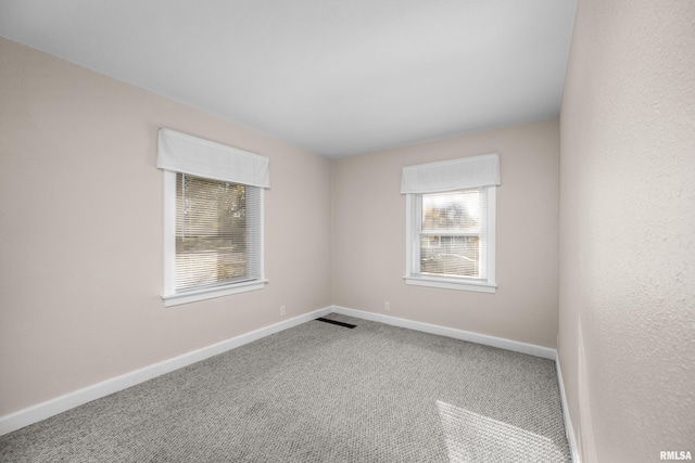 empty room featuring a healthy amount of sunlight and carpet floors