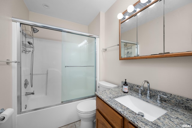 full bathroom with bath / shower combo with glass door, vanity, toilet, and tile patterned flooring