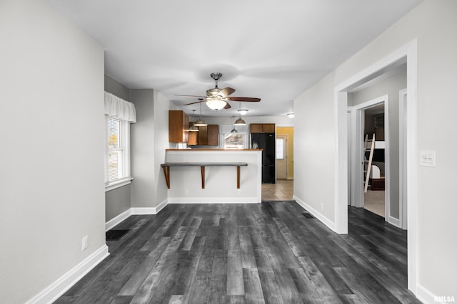 unfurnished living room with dark hardwood / wood-style floors and ceiling fan