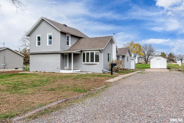 view of front of house with a front lawn and a storage unit