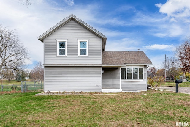 rear view of house featuring a yard