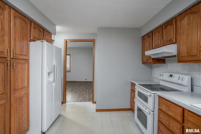 kitchen featuring white appliances, light hardwood / wood-style floors, and backsplash