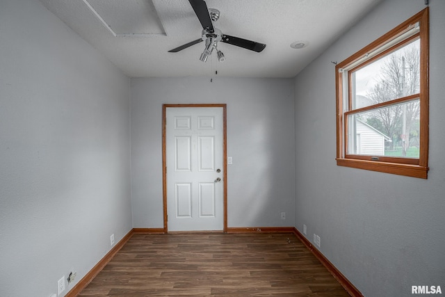 empty room featuring a textured ceiling, dark hardwood / wood-style flooring, and ceiling fan