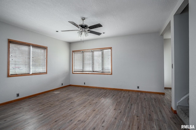 spare room with ceiling fan, dark hardwood / wood-style flooring, and a textured ceiling