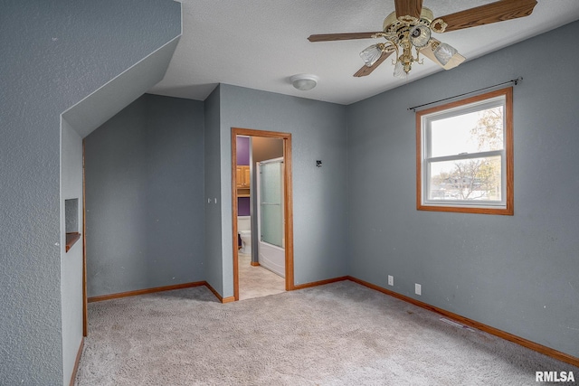 bonus room featuring vaulted ceiling, ceiling fan, light colored carpet, and a textured ceiling