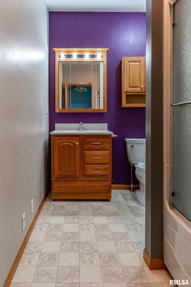 full bathroom with vanity, bath / shower combo with glass door, and toilet