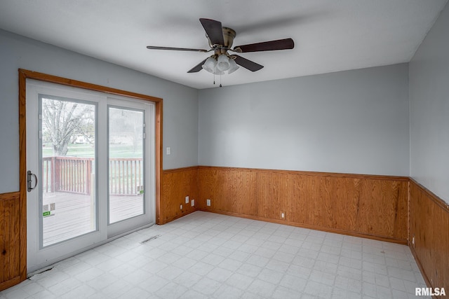 spare room with wood walls and ceiling fan