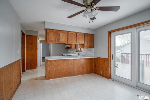 kitchen with ceiling fan, sink, tasteful backsplash, kitchen peninsula, and white appliances