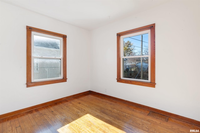 unfurnished room featuring wood-type flooring and plenty of natural light