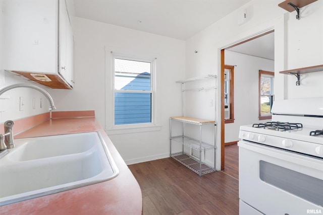 kitchen with white range with gas cooktop, dark hardwood / wood-style flooring, sink, and white cabinets