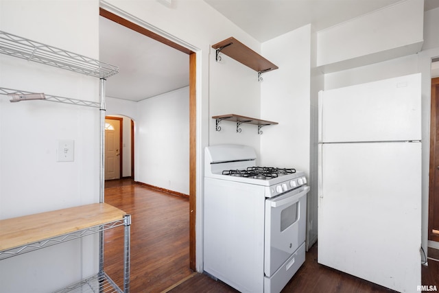 kitchen with white appliances and dark hardwood / wood-style flooring