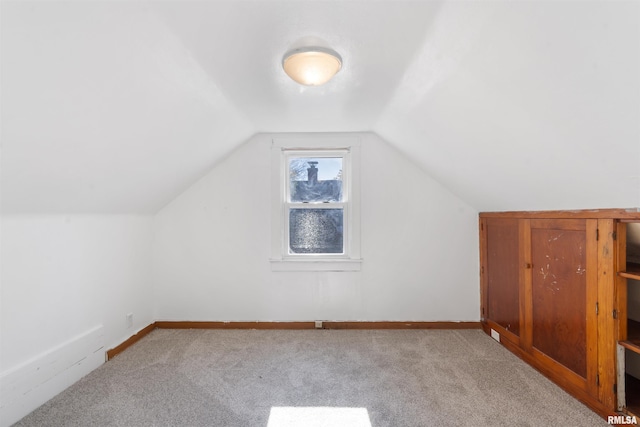 additional living space with light carpet and vaulted ceiling