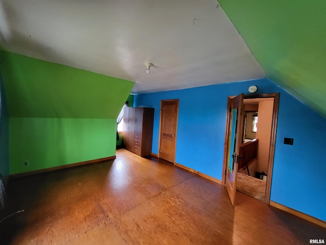 additional living space featuring wood-type flooring and vaulted ceiling