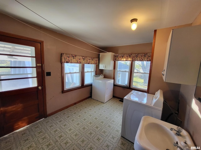 washroom featuring separate washer and dryer, sink, and a healthy amount of sunlight