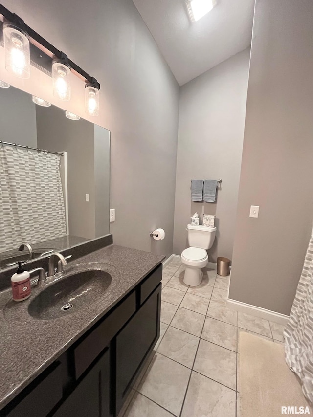 bathroom with tile patterned flooring, vanity, toilet, and lofted ceiling