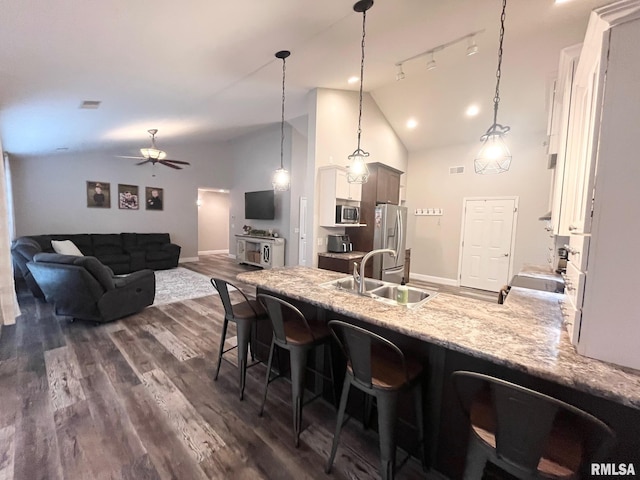 kitchen featuring a breakfast bar area, dark wood-type flooring, pendant lighting, and appliances with stainless steel finishes