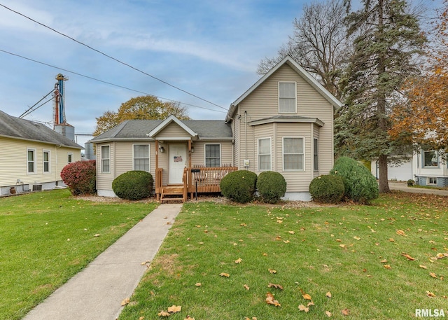 bungalow featuring a front lawn and a wooden deck