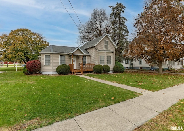 bungalow featuring a front yard and a wooden deck