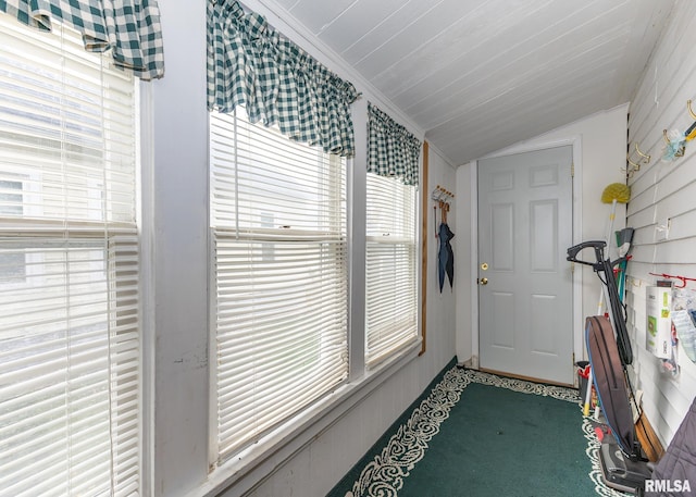 entryway with carpet, vaulted ceiling, and crown molding