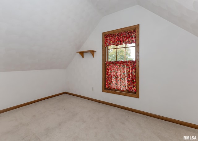 bonus room featuring light carpet and vaulted ceiling