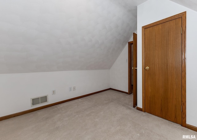 additional living space featuring light carpet and lofted ceiling