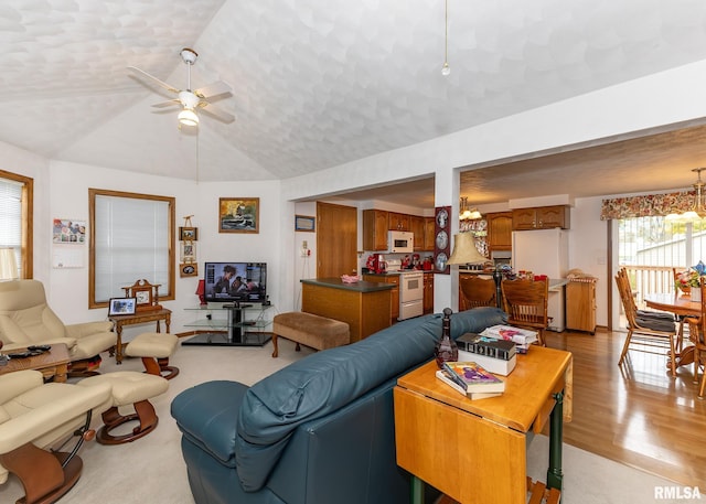 living room with light hardwood / wood-style flooring, ceiling fan with notable chandelier, and lofted ceiling