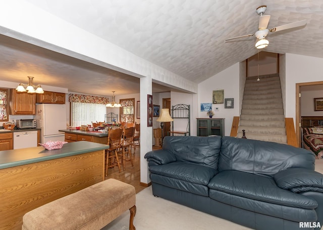 carpeted living room featuring a textured ceiling, ceiling fan with notable chandelier, and lofted ceiling