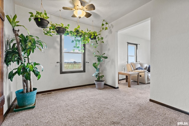 sitting room with carpet and ceiling fan