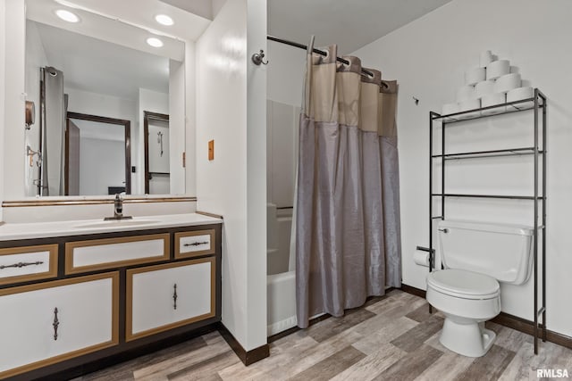 full bathroom with hardwood / wood-style floors, vanity, toilet, and shower / bathtub combination with curtain