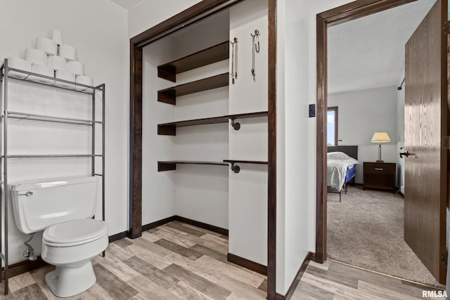 bathroom featuring toilet, a textured ceiling, and hardwood / wood-style flooring