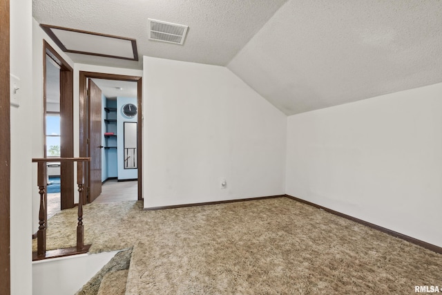 bonus room featuring a textured ceiling, light colored carpet, and lofted ceiling