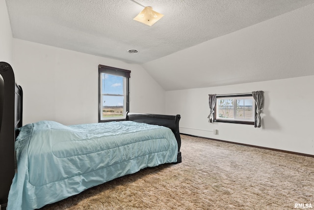 carpeted bedroom with a textured ceiling, vaulted ceiling, and multiple windows