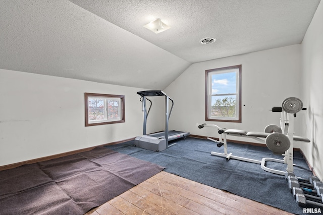 exercise area with a textured ceiling, hardwood / wood-style floors, and plenty of natural light