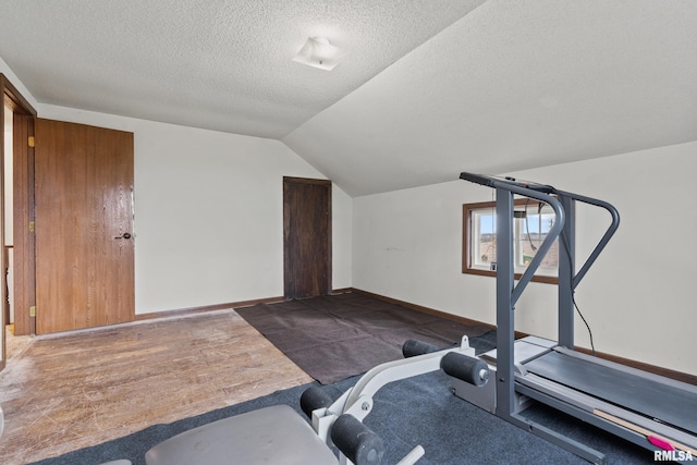 workout area with a textured ceiling, dark hardwood / wood-style floors, and lofted ceiling