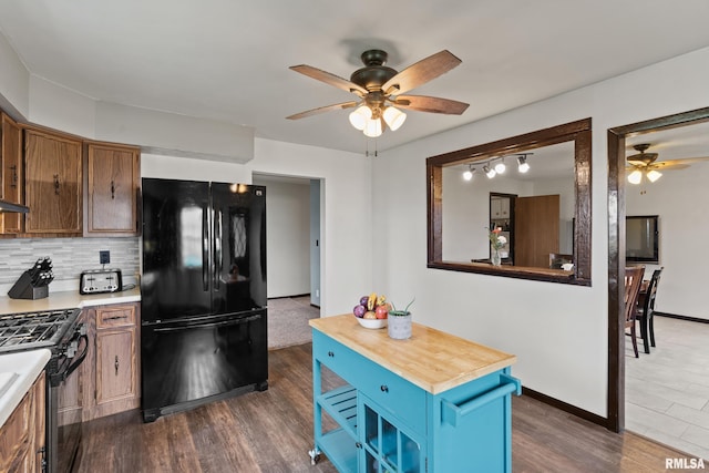 kitchen with ceiling fan, dark hardwood / wood-style flooring, backsplash, butcher block countertops, and black appliances