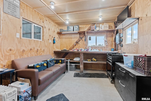 miscellaneous room featuring a workshop area and wood walls