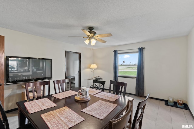 tiled dining area with ceiling fan and a textured ceiling