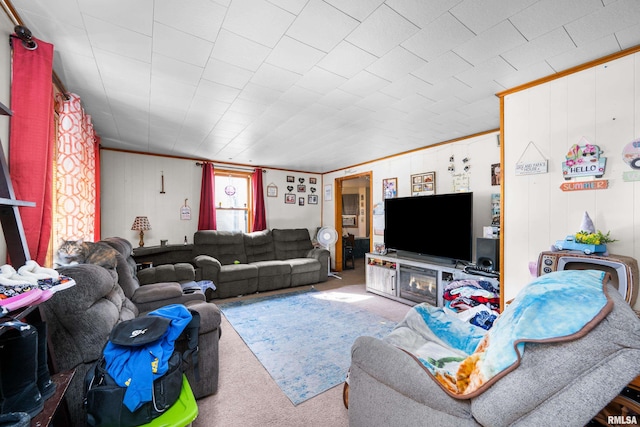 carpeted living room featuring wood walls