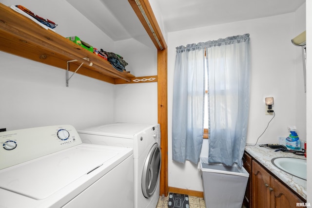 clothes washing area featuring washer and dryer, a healthy amount of sunlight, and sink