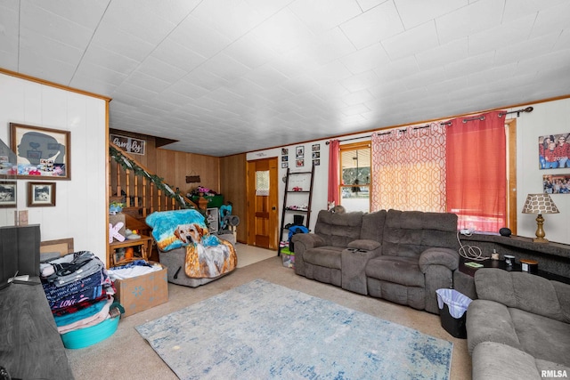 carpeted living room featuring wood walls