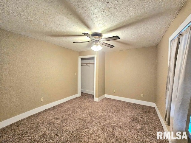 unfurnished bedroom featuring a closet, a textured ceiling, carpet floors, and ceiling fan