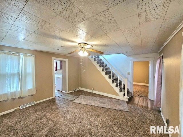 interior space with a paneled ceiling and ceiling fan