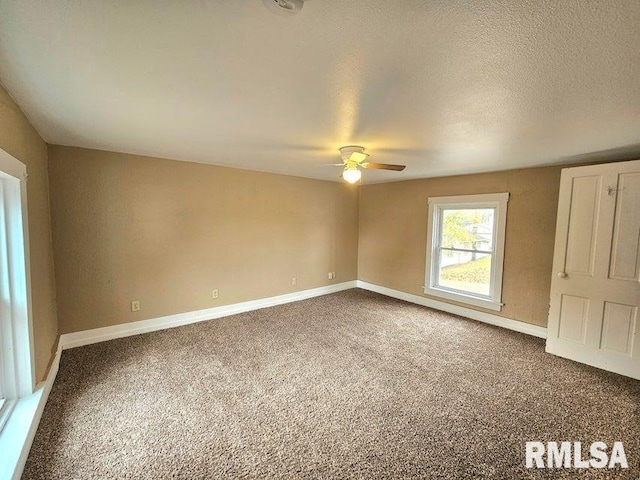 empty room with ceiling fan, carpet floors, and a textured ceiling