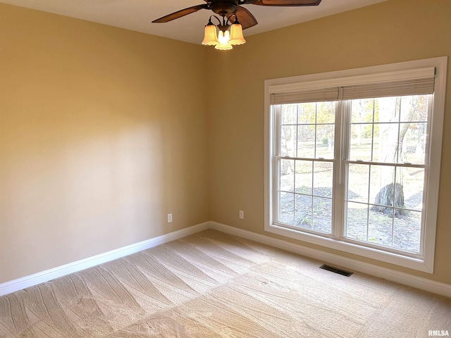 spare room featuring light colored carpet and ceiling fan