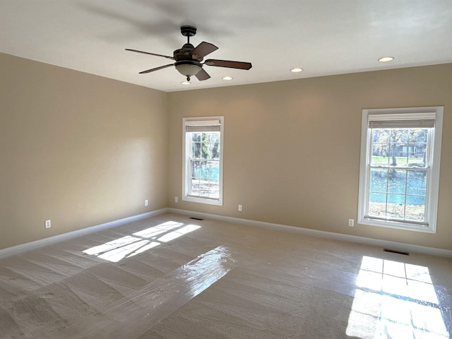 carpeted empty room featuring plenty of natural light and ceiling fan