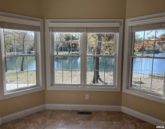 interior space with plenty of natural light and a water view