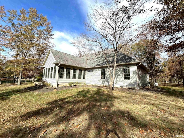 rear view of property featuring a lawn and a sunroom