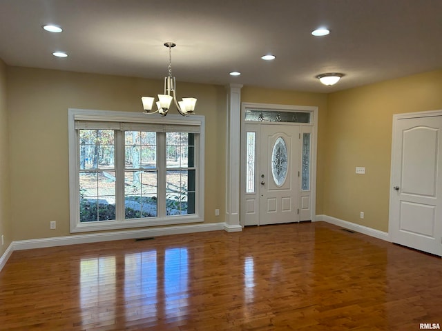 foyer entrance with a chandelier and wood-type flooring